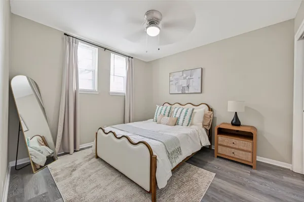 a bedroom with a bed wooden floor and a window