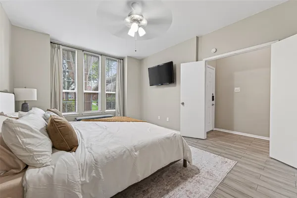 a bedroom with a large bed and a flat tv screen