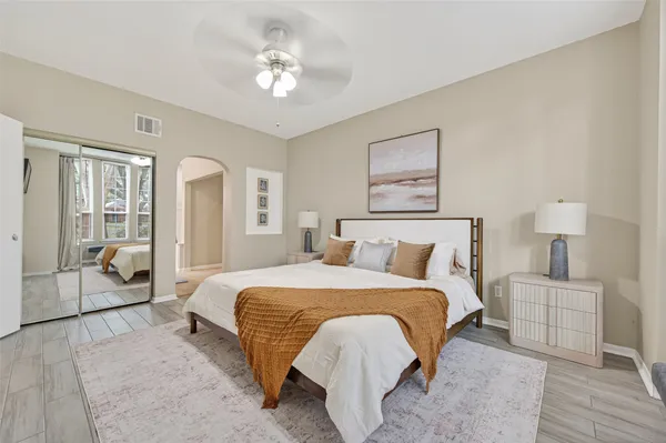 a spacious bedroom with a bed and a chandelier