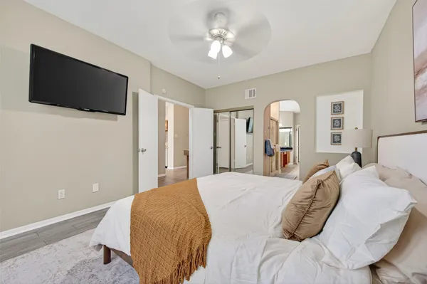 a spacious bedroom with a bed and a flat screen tv