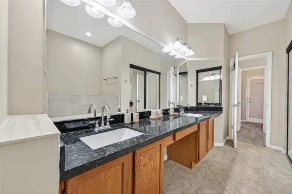a bathroom with a granite countertop double sink and a mirror