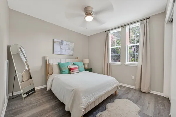 a bedroom with a bed wooden floor and a window