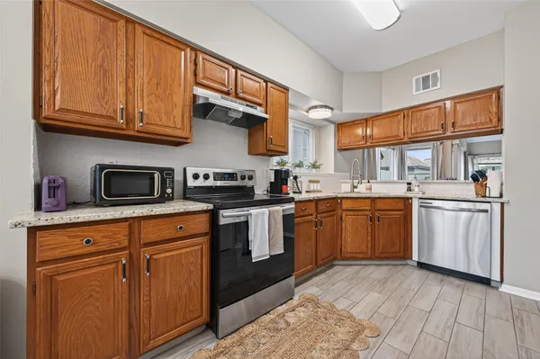 a kitchen with stainless steel appliances granite countertop a stove sink and cabinets