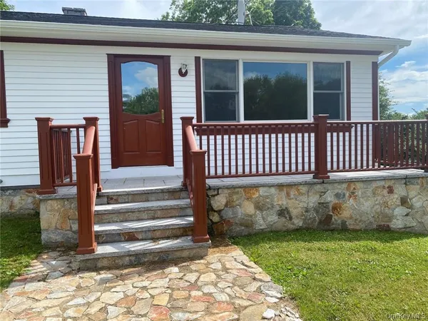 a view of a house with a small yard and wooden floor and fence