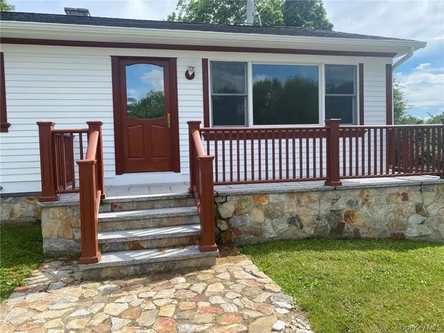 a view of a house with a small yard and wooden floor and fence