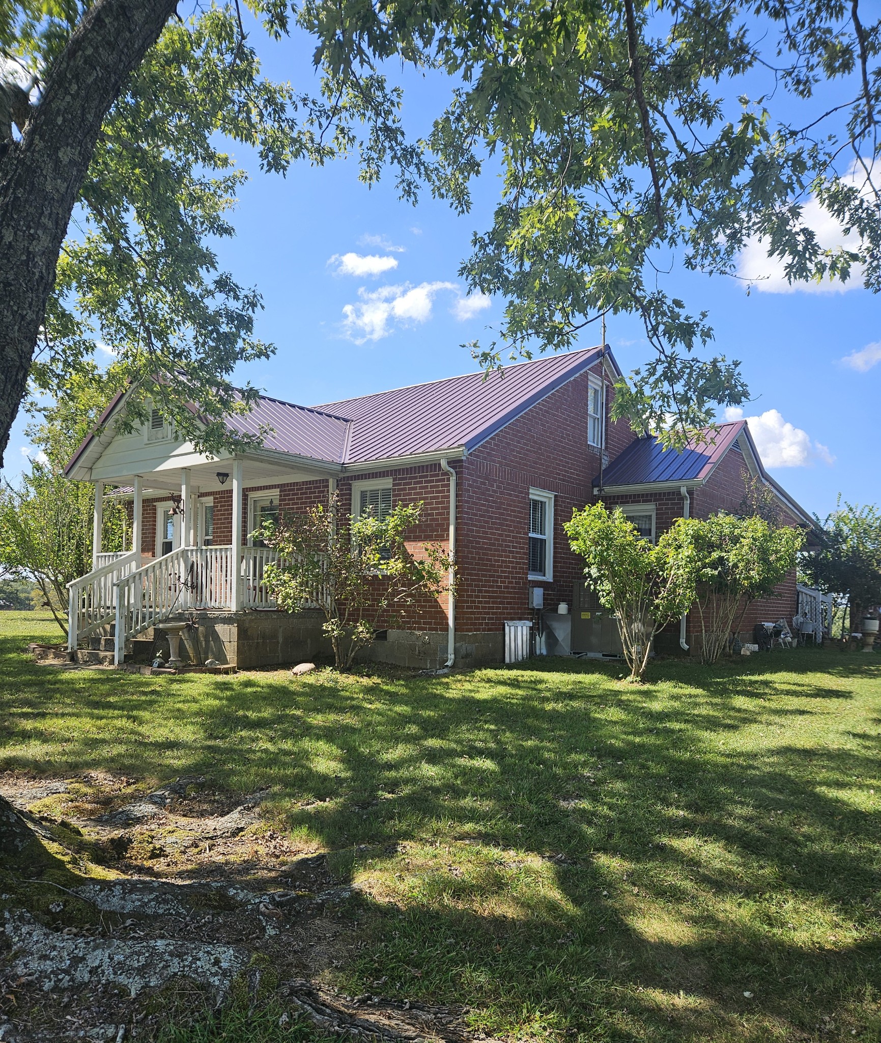 a view of a house with a big yard and a large tree