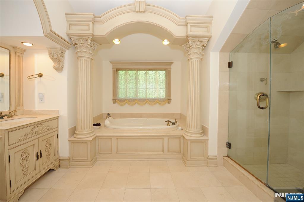 273 Joshua Lane Wyckoff, NJ 07481 - Photo 15 of 17 a spacious bathroom with a granite countertop sink a mirror a bathtub and shower