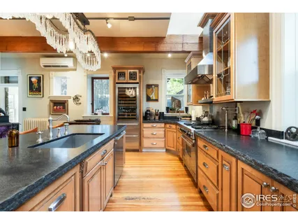 a large kitchen with stainless steel appliances granite countertop a sink and cabinets