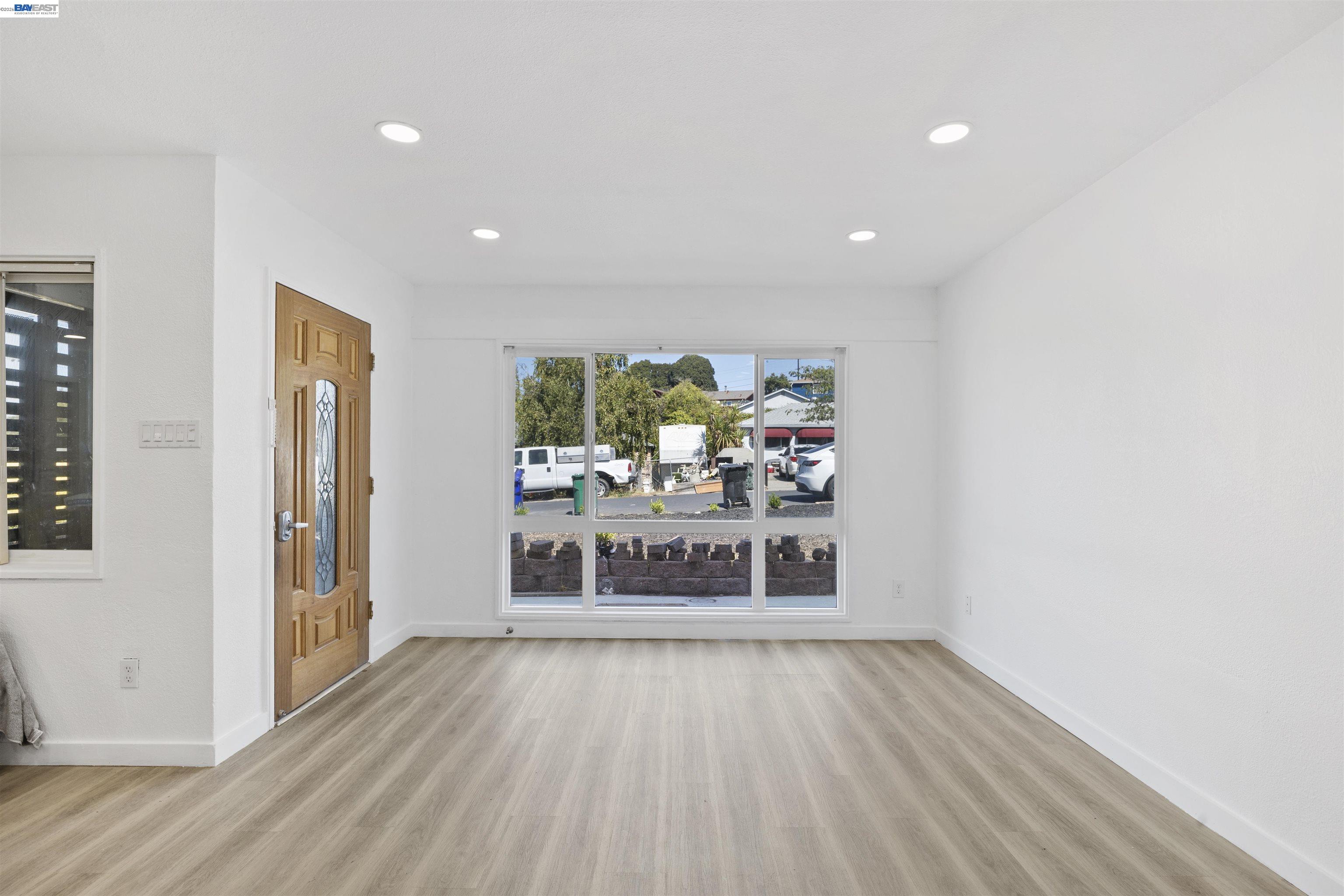 923 Kelvin Road El Sobrante, CA 94803 - Photo 13 of 27 wooden floor in an empty room with a window