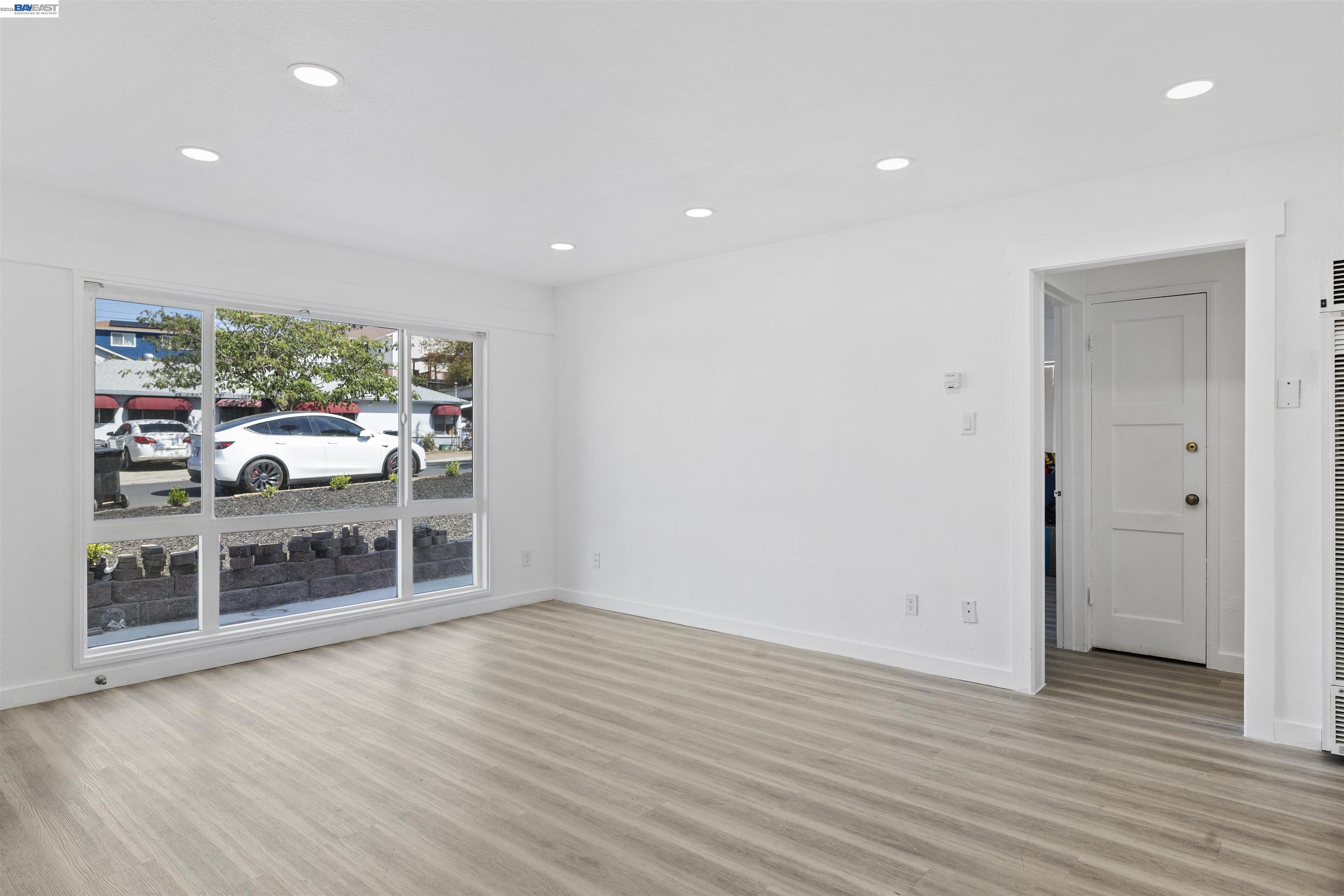 923 Kelvin Road El Sobrante, CA 94803 - Photo 14 of 27 an empty room with wooden floor and windows