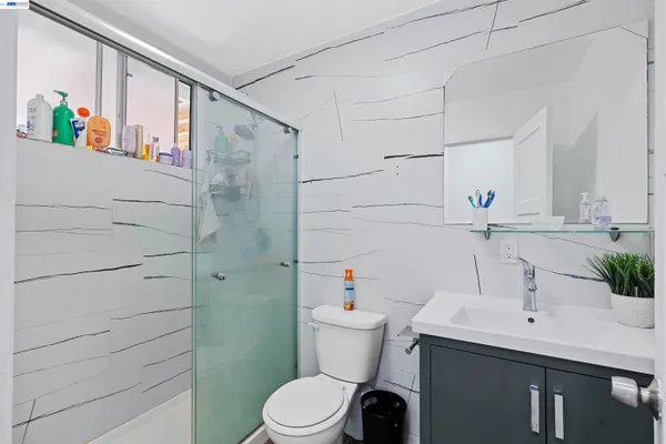 a bathroom with a sink a toilet and shower