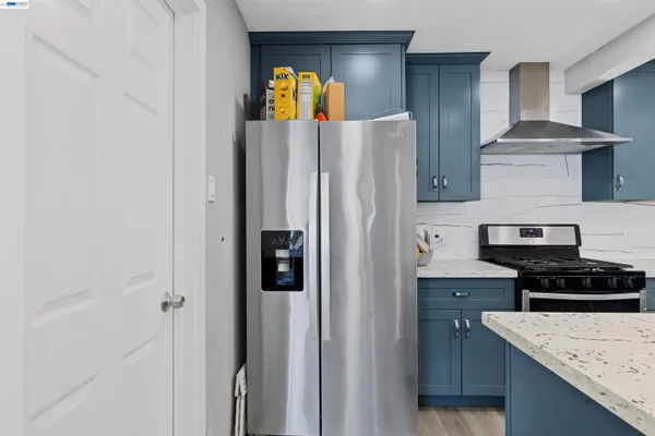 a kitchen with stainless steel appliances granite countertop a refrigerator and a stove top oven