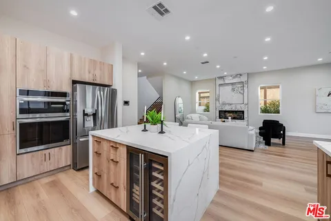 a kitchen with stainless steel appliances kitchen island granite countertop a refrigerator and a stove top oven