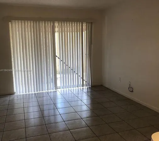 a view of a livingroom with a floor to ceiling window and brick wall