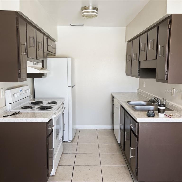 5200 Curry Ford Road, Unit 102 Orlando, FL 32812 - Photo 5 of 23 a kitchen with a sink stove and cabinets