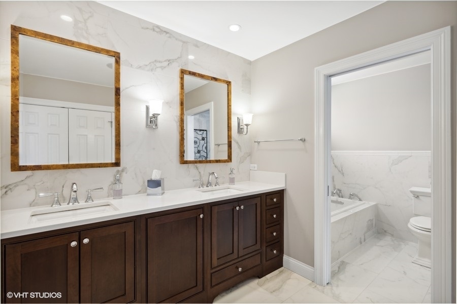 1335 North Sutton Place Chicago, IL 60610 - Photo 13 of 31 a bathroom with a double vanity sink toilet mirror and bathtub