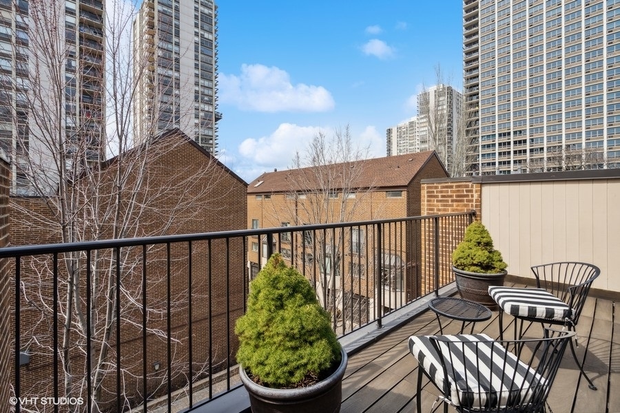 1335 North Sutton Place Chicago, IL 60610 - Photo 23 of 31 a view of a balcony with wooden chairs