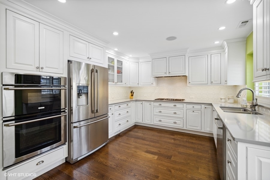 1335 North Sutton Place Chicago, IL 60610 - Photo 5 of 31 a kitchen with granite countertop white cabinets and stainless steel appliances