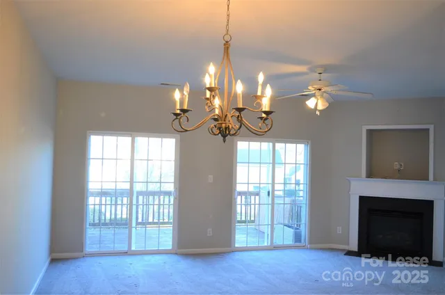a view of a livingroom with a chandelier fan and a fireplace
