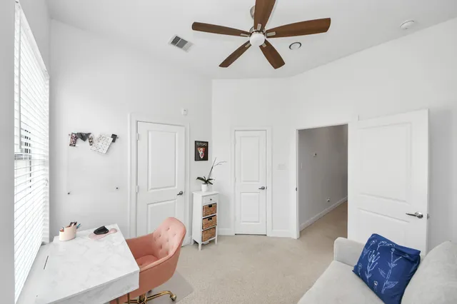a living room with furniture and a ceiling fan