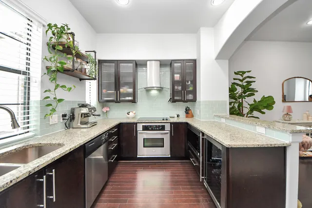 a kitchen with stainless steel appliances granite countertop a sink stove and cabinets