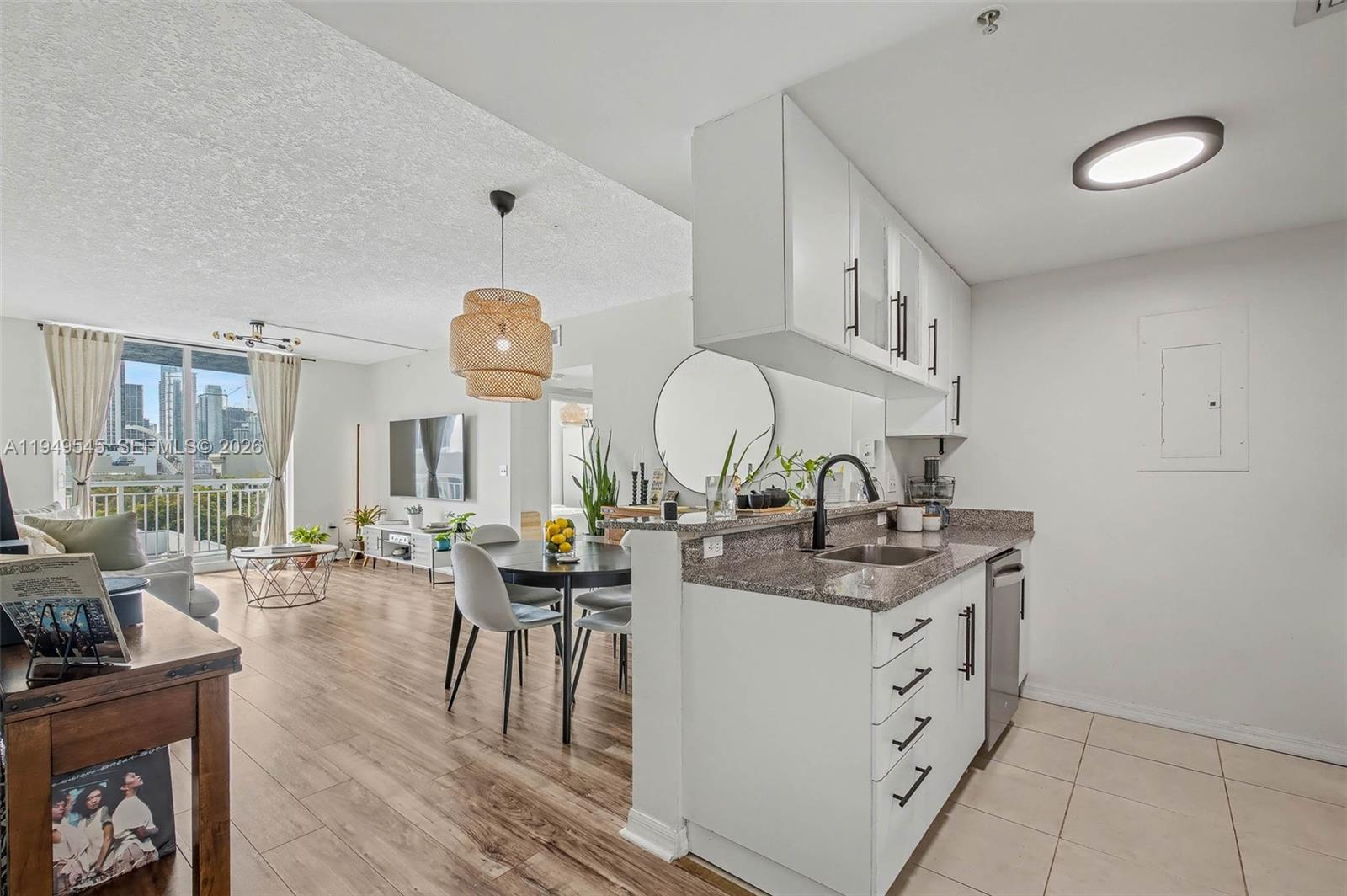 275 Northeast 18th Street, Unit 703 Miami, FL 33132 - Photo 4 of 28 a very nice looking kitchen with granite countertop a stove a sink a dining table and chairs