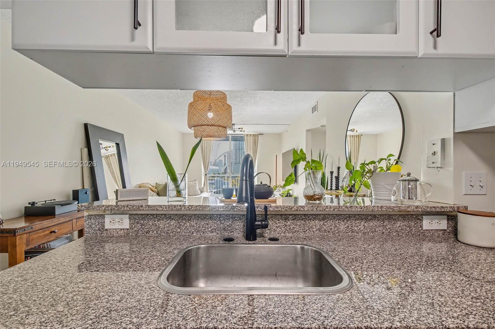 275 Northeast 18th Street, Unit 703 Miami, FL 33132 - Photo 7 of 28 a kitchen sink with a granite counter top and a potted plant
