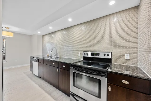 a kitchen with stainless steel appliances granite countertop a stove and a sink