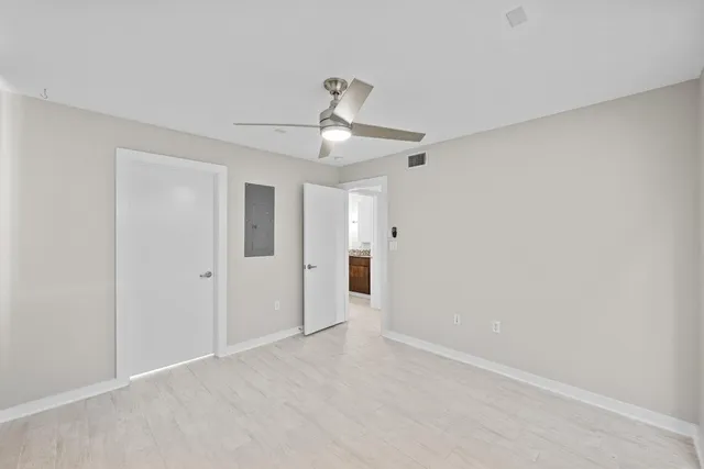 a view of an empty room and chandelier fan