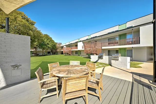 a view of a patio with table and chairs with wooden floor and fence