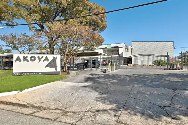 a view of a house with a big yard and large trees