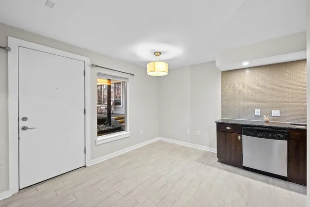 a view of an empty room with window and mirror