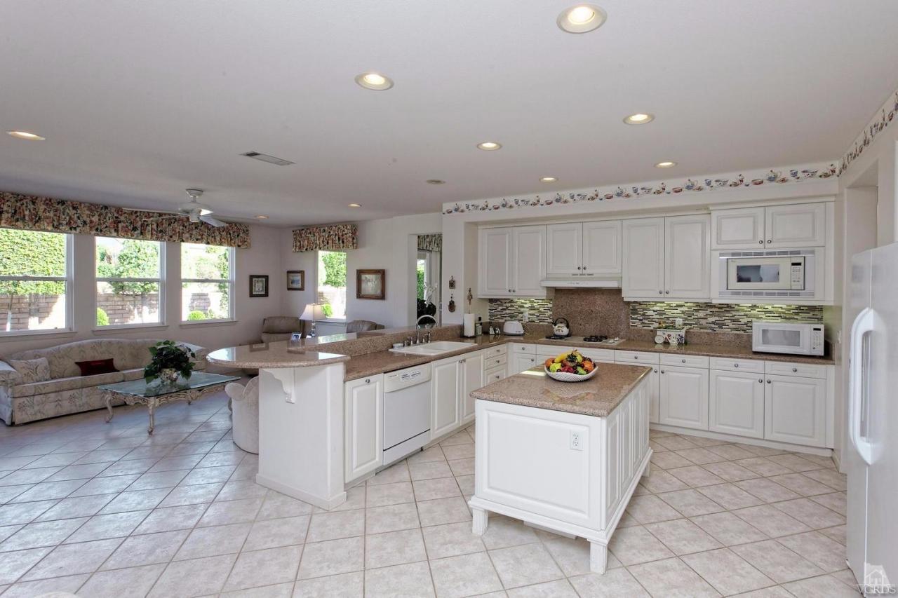 3248 Bluebird Circle Simi Valley, CA 93063 - Photo 5 of 28 a kitchen with white cabinets and white appliances