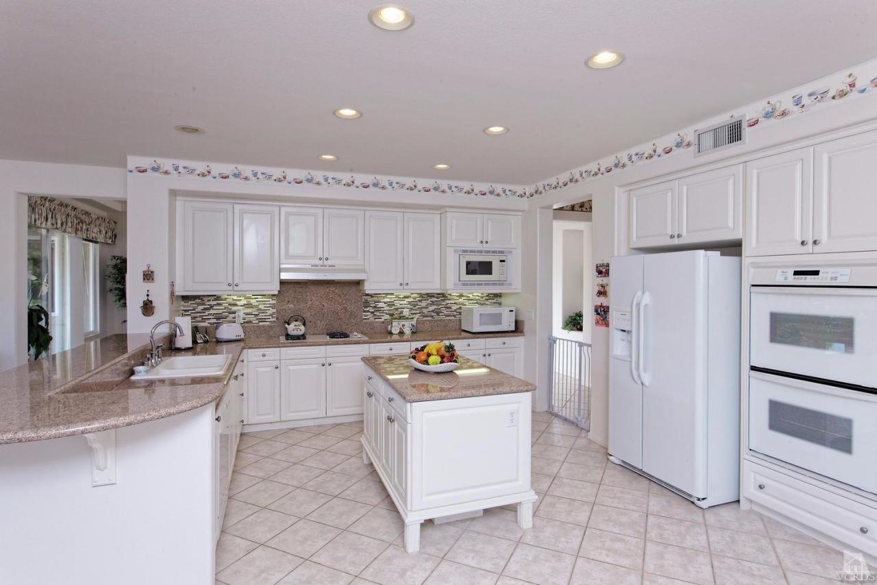 3248 Bluebird Circle Simi Valley, CA 93063 - Photo 7 of 28 a kitchen with white cabinets and stainless steel appliances