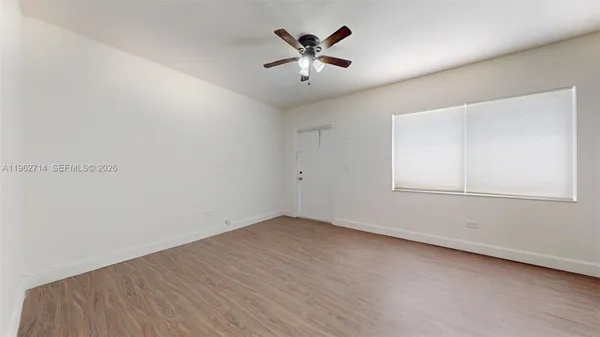 an empty room with a window and wooden floor