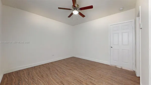 a view of an empty room with wooden floor
