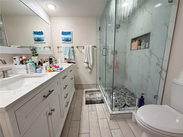 a bathroom with a sink a toilet and shower