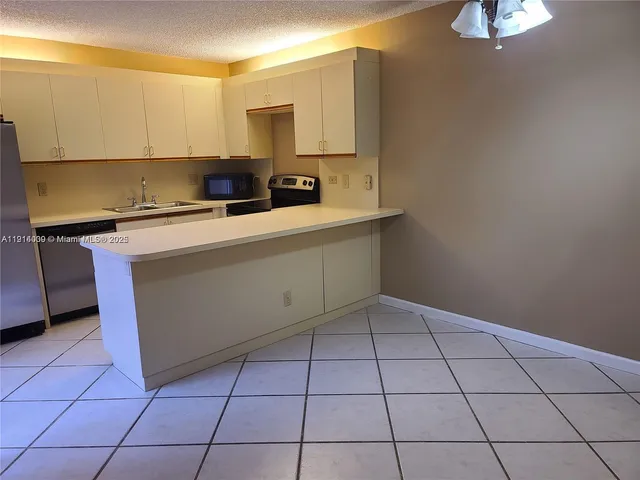 a kitchen with a sink a stove and cabinets