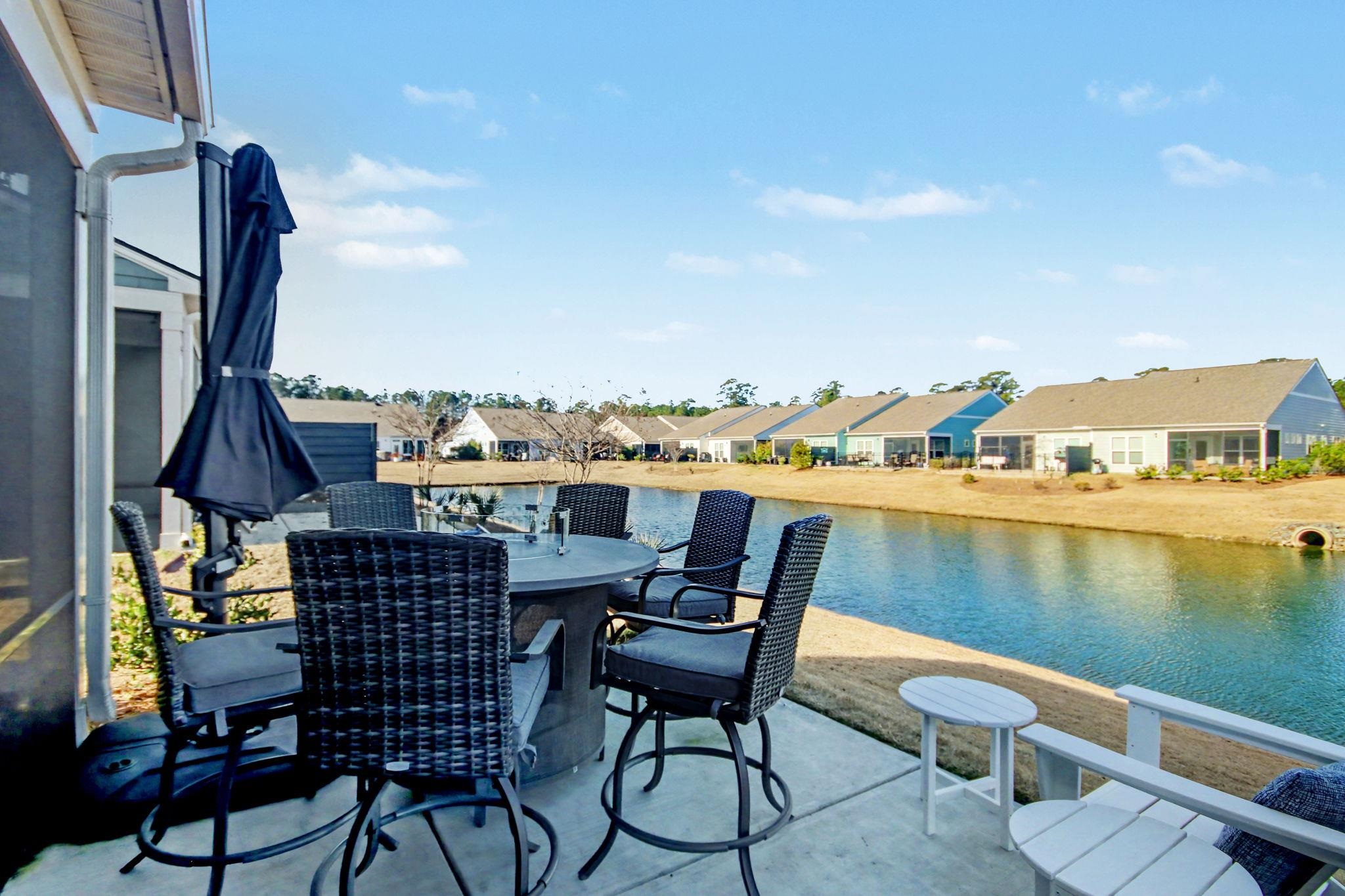 5830 Cremona Drive Myrtle Beach, SC 29577 - Photo 25 of 39 View of patio featuring a residential view, outdoor dining space, and a water view