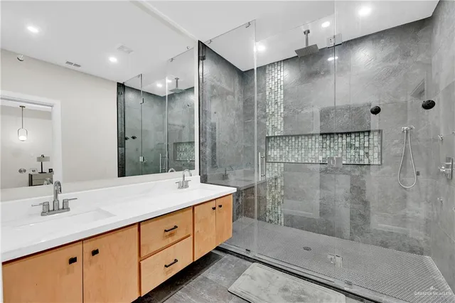 a bathroom with a shower sink and mirror