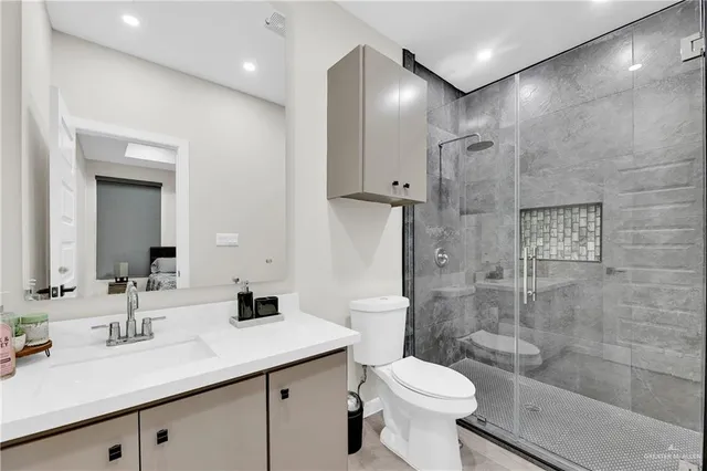 a bathroom with a sink toilet a mirror and shower