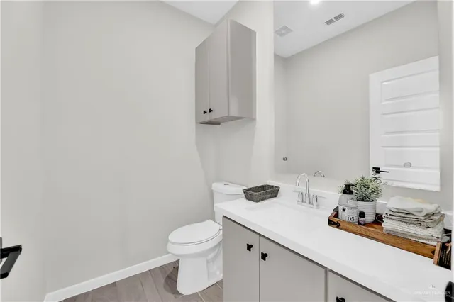 a bathroom with a sink vanity and toilet