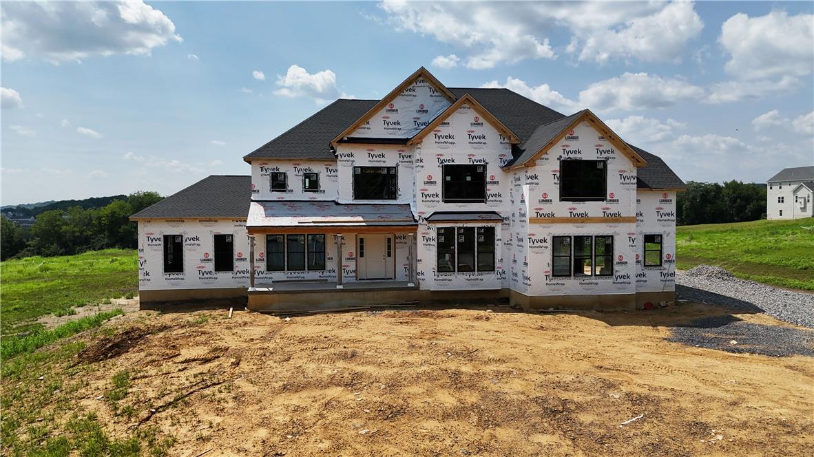 A newly constructed residence, wrapped in weather-resistant sheathing, awaits its final exterior finishes.