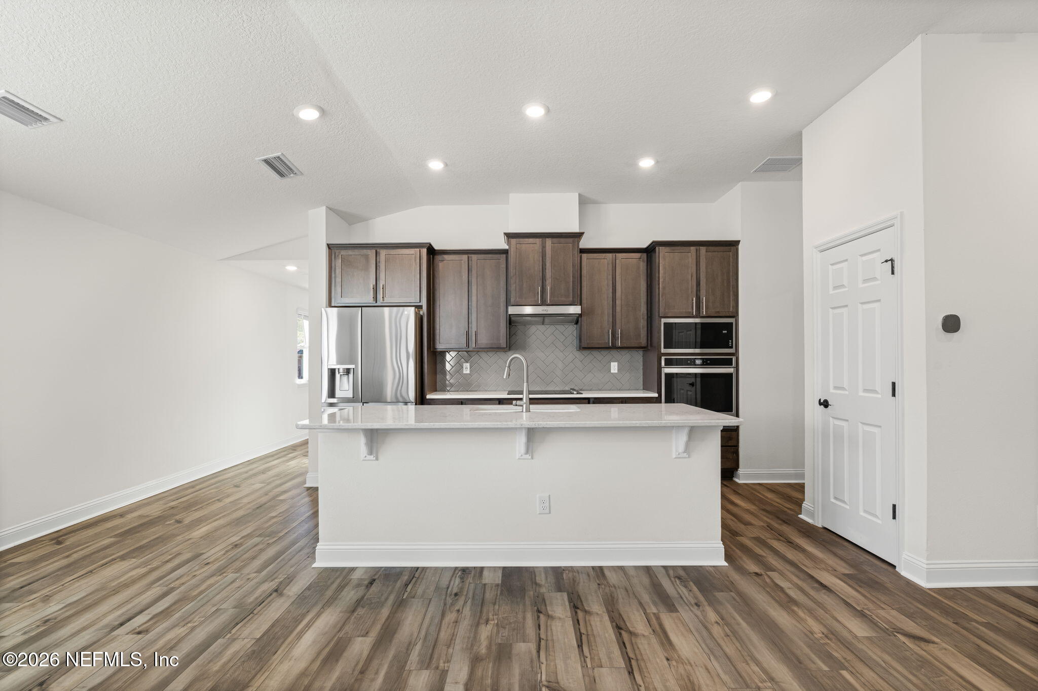 277 Rambling Brk Trail St. Johns, FL 32259 - Photo 6 of 51 a large kitchen with stainless steel appliances a large counter top a stove and a refrigerator with wooden floor