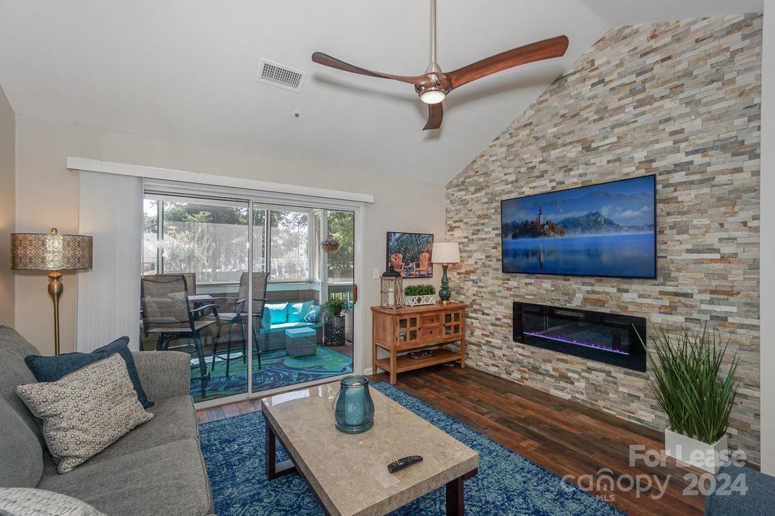 17542 Tuscany Lane Cornelius, NC 28031 - Photo 11 of 35 a living room with furniture a flat screen tv and a fireplace