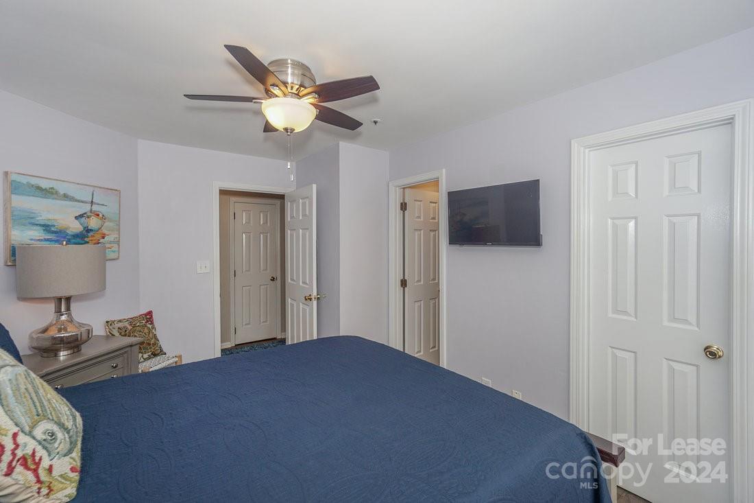 17542 Tuscany Lane Cornelius, NC 28031 - Photo 25 of 35 a bedroom with a bed and a chandelier