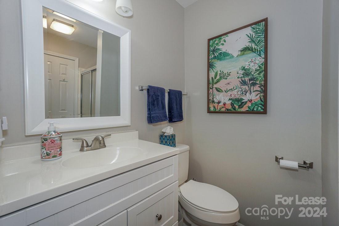 17542 Tuscany Lane Cornelius, NC 28031 - Photo 27 of 35 a bathroom with a toilet a sink a mirror and vanity