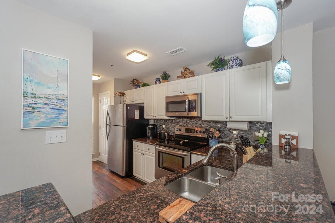 17542 Tuscany Lane Cornelius, NC 28031 - Photo 4 of 35 a kitchen with stainless steel appliances granite countertop a stove top oven a sink a refrigerator and a microwave