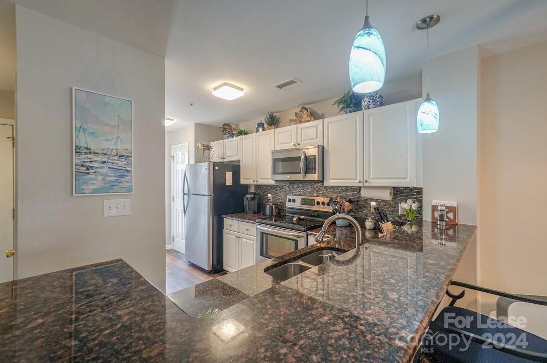 17542 Tuscany Lane Cornelius, NC 28031 - Photo 5 of 35 a kitchen with sink refrigerator and stove