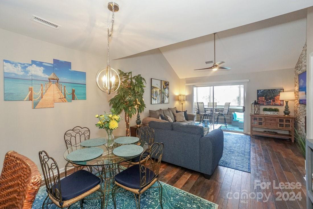 17542 Tuscany Lane Cornelius, NC 28031 - Photo 9 of 35 a living room with furniture a chandelier and a dining table
